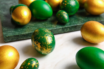 Board with stylish Easter eggs on light background