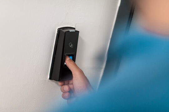 Man Pressing Fingerprint Scanner On Alarm System IndoorsFinger Print Scan For Unlock Door Security System