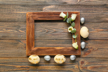 Beautiful composition with frame, Easter eggs and flowers on wooden background