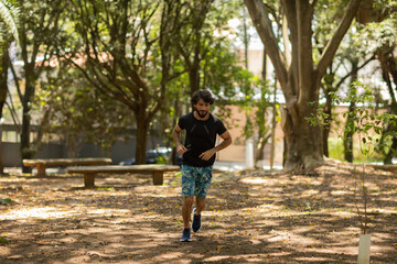 Young guy running and jogging at a park outdoors. Athlete male person during workout. High quality photo