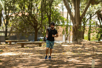 Obraz premium Young guy running and jogging at a park outdoors. Athlete male person during workout. High quality photo