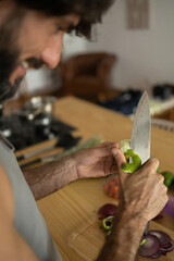 Happy and healthy young man meal prepping whole vegetarian meal in the kitchen. High quality photo