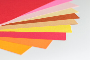 扇形に重ねて並べられたカラフルな暖色系の画用紙