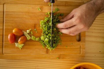 Happy and healthy young man meal prepping whole vegetarian meal in the kitchen. High quality photo