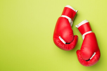 Pair of red boxing gloves on color background. Top view