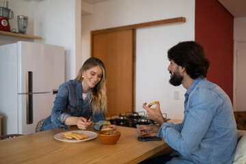 Young couple in love eating a super healthy guacamole salad with whole toast in the kitchen. High quality photo