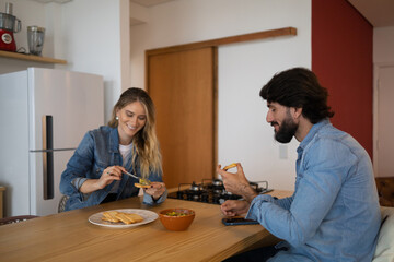 Young couple in love eating a super healthy guacamole salad with whole toast in the kitchen. High quality photo