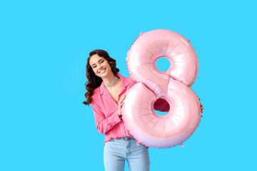 Smiling young woman with big balloon in shape of figure 8 on blue background. International Women's Day - obrazy, fototapety, plakaty