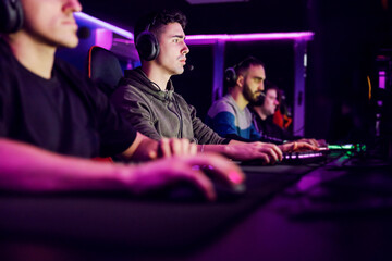 A gaming team sitting at gaming room and having gaming tournament.