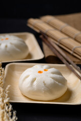 Steamed Chinese bun stuffed with minced pork, egg yolk or sweet on natural plate, Asian food