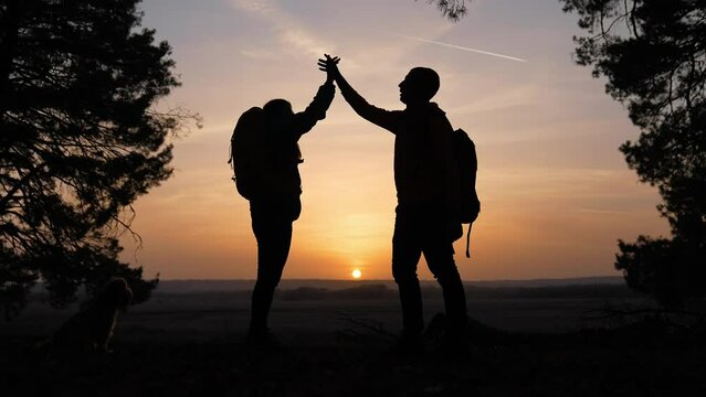 teamwork. business a journey concept win. happy family team tourists man and woman sunset silhouette help shake teamwork hands victory success business . slow motion video. group tourism husband top