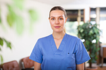 Portrait of friendly female doctor wearing uniform standing in modern clinic
