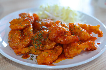 Shrimp dishes fried in chili sauce are served on a white plate.