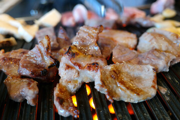 Pork is being grilled on a grill.