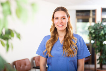 Portrait of friendly female doctor wearing uniform standing in modern clinic