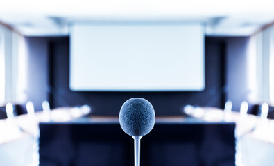 Close up microphone center of picture with screen projector background in meeting