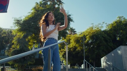 Girl tourist posing on park stairs. Carefree asian woman make selfie on walking.