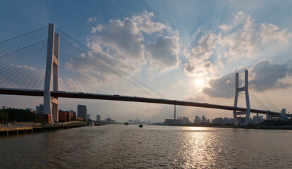 Landscape of Shanghai Nanpu bridge and city skyline viewed from sailing ship in sunny day.