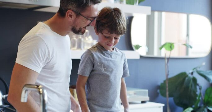 Add a dash of fun. 4k video footage of an adorable little boy baking with his father at home.