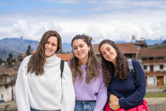 Portrait of three student girls smiling to the camera outdoors