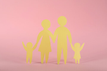 Paper family figure on pink background. Child adoption concept