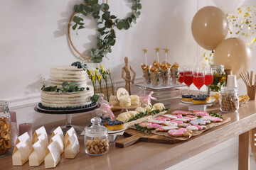 Baby shower party. Different delicious treats on wooden table indoors