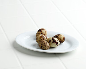 Quail eggs on white plate and white table.