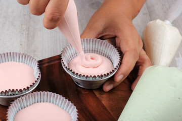 Female Hand Pour Pink Cupcake Batter to the Mold with Beatiful Papercup, Baking Process Step by...