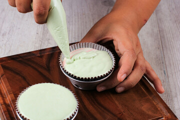 Female Hand Pour Green Cupcake Batter to the Mold with Beatiful Papercup, Baking Process Step by Step in the Kitchen. Making Bolu Kukus