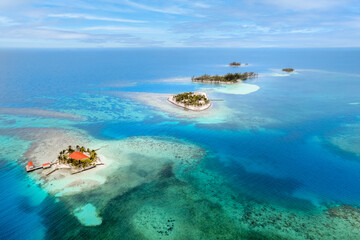 Fototapeta na wymiar Remote tropical surrounded by turquoise water and vibrant reef, Utila Cays Honduras
