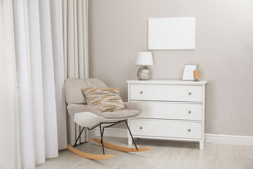Blank canvas on wall over chest of drawers with decor in room. Space for design