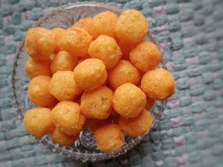 Cheese puffs balls, cheese curls, cheese ball puffs, cheesy puffs, or corn curls are a puffed corn snack, coated with a mixture of cheese or cheese-flavored powders.