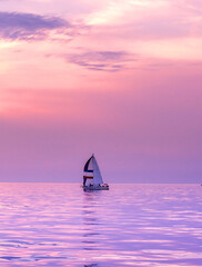  Small Sail boat in a pink and purple sunset on lake Michigan in Michigan USA