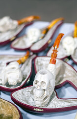  Carved Skull Meerschaum pipes  are on display  at a pipe show