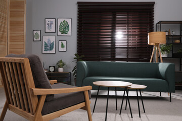 Fototapeta na wymiar Stylish living room interior with comfortable sofa and armchair