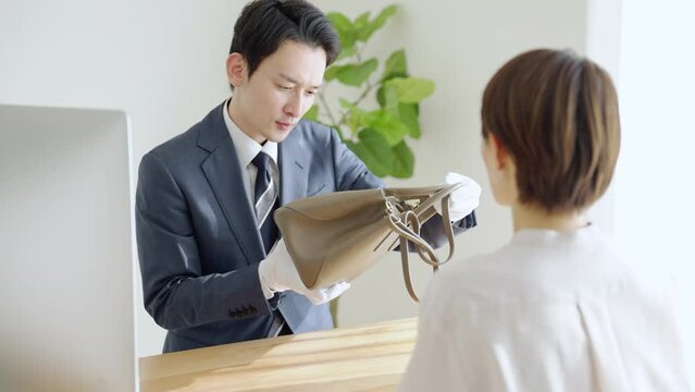 60p　バッグを査定する鑑定士と客