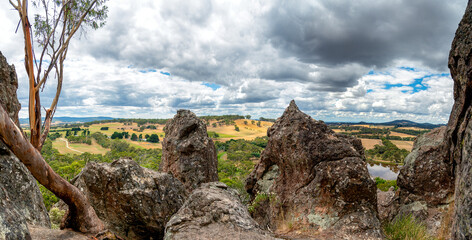 A panoramic view from Hanging Rock in Victoria, Australia, with volcanic boulders in the foreground...