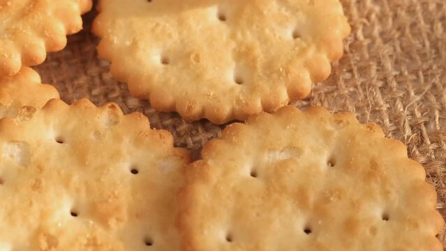 Circle crackers with salt. Close up. Rotating cracker cookies background. Tasty food. Beautiful round crackers on canvas