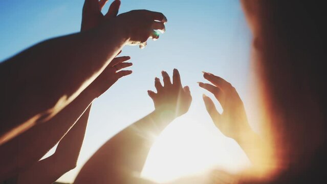 group of cheerful people together party pulling hands to the sun on the beach. teamwork. silhouette people party fun dancing recreation holiday. people music. pull their hands up. religion concept