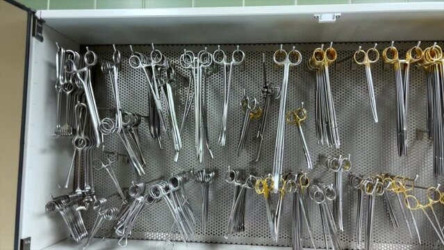 various surgical instruments hang in a cabinet in the operating room