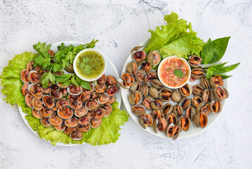 Peeled cockles with seafood sauce and vegetable salad lettuce on plate  background, Fresh raw...