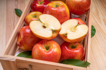 Naklejka na ściany i meble Fresh red Envy apple in wooden basket on wooden background. Envy apple on wooden box packaging ready to sell.