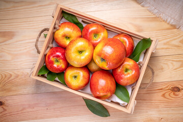 Fresh red Envy apple in wooden basket on wooden background. Envy apple on wooden box packaging...