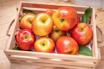 Fresh red Envy apple in wooden basket on wooden background. Envy apple on wooden box packaging ready to sell.