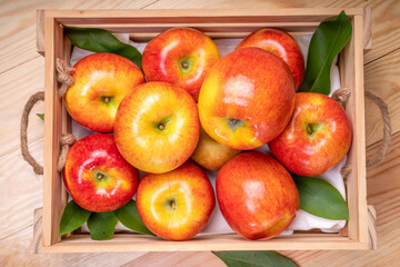 Fresh red Envy apple in wooden basket on wooden background. Envy apple on wooden box packaging ready to sell.
