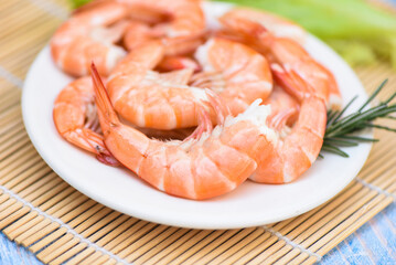 fresh shrimps served on white plate with rosemary, boiled peeled shrimp prawns cooked in the seafood restaurant