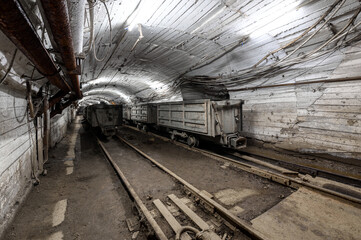 Fototapeta na wymiar Underground mine. Underground railway for transporting ore. Mine trolley as part of an underground freight train