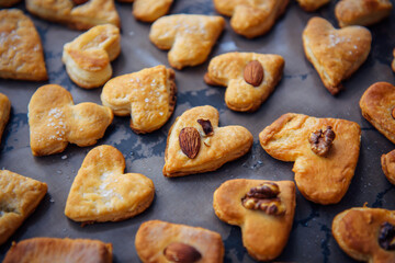 Freshly puff dough heart shaped cookies, top view close up. St Valentine's Day concept. Abstract bakery background with copy space.