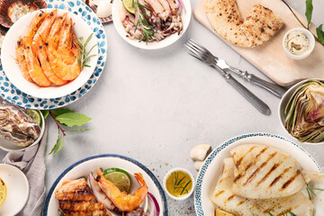Grilled fish and seafood assortment on light background.