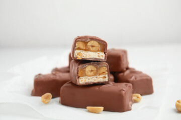 Chocolate bars with caramel, nuts and nougat on white table, closeup